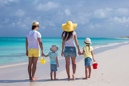 年轻家庭与两个孩子在卡利比恩度假的背影 绿松石图片