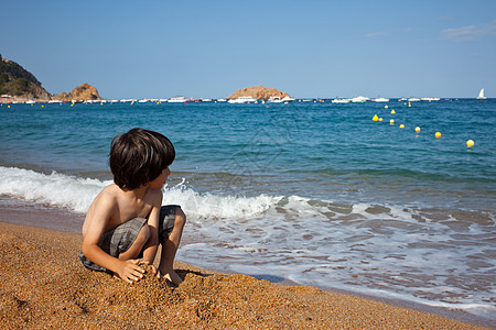 男孩在海边的海岸上图片