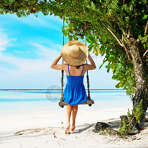 穿蓝裙子的女人在海滩摆动 女孩 帽子 热带 岛图片