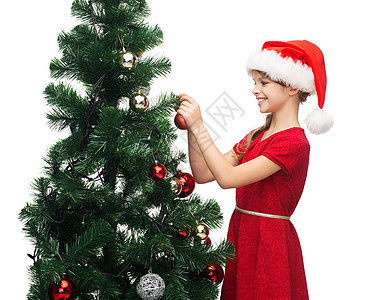 穿着圣诞帮手帽子的笑笑着女孩 装饰一棵树 假期 圣诞节图片