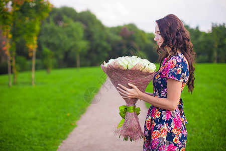 玫瑰摆拍美丽的年轻美女 带着一束白玫瑰花 婚礼 植物群背景