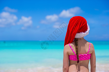 红色圣诞礼帽的小可爱女孩享受沙滩度假 快乐图片