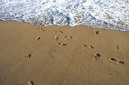 海洋沙滩和海浪上的赤脚足足足迹图片