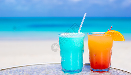 在白沙滩上 紧贴蓝色的库拉索和芒果鸡尾酒 玻璃 夏天图片