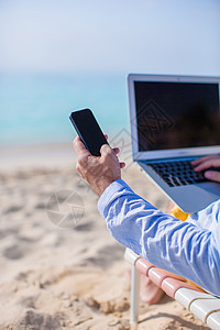 封锁海滩电脑背景的电话; 在海滩上关闭计算机背景 无线上网 自由职业者图片
