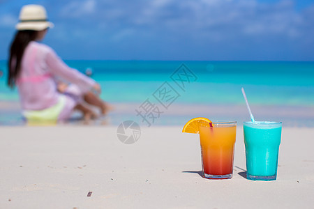 在海滩背景的年轻女孩身上 贴上美味的鸡尾酒图片
