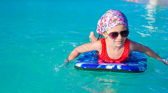 在松绿海的冲浪板上的小可爱女孩 游泳衣 比基尼 假期图片