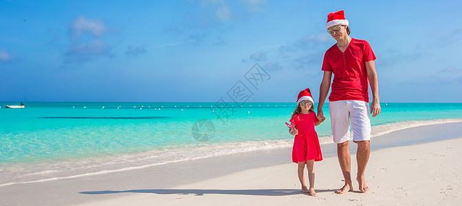 在热带海滩的圣诞礼帽家庭图片