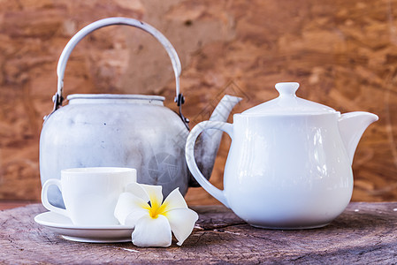 白杯和frangipani与白色茶壶背景图片