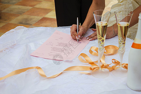 新娘在结婚证上签名时手的细节 婚礼 在户外婚礼上的香槟酒杯 婚礼用的香槟酒杯图片