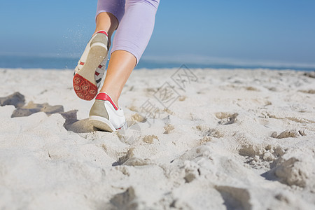 运动的女性脚踏在沙滩上慢跑 水 紫色的 假期 合身图片