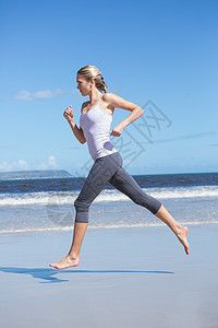 光脚在海滩上跑步的金发美女图片