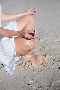 穿着白裙子的女人在沙滩上冥想图片