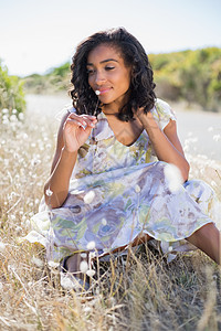 坐在草地上穿花花裙子的快乐漂亮女人 混血 晴天背景图片