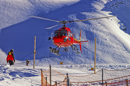 红色直升机降落在附近的Swis滑雪胜地 白色的图片
