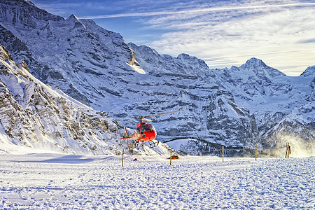 红直升机在Jungfrau山附近的Swis Skia度假胜地起飞图片