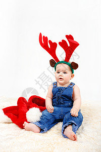 拥有圣诞圣塔帽和驯鹿鹿角的女童图片