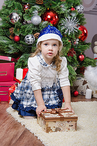 圣诞树上送礼物的三岁女孩背景图片