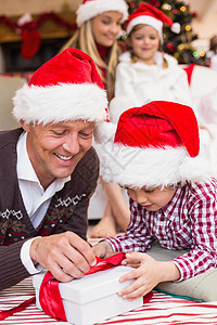节日父亲和儿子在圣诞节开幕礼物 圣诞帽 家庭生活 女儿图片
