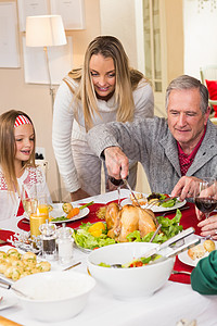 爷爷在圣诞节晚宴上切鸡肉 家庭生活 桌子 闲暇 客厅图片