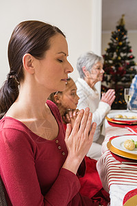 圣诞晚餐在圣诞节晚宴前扩大家庭祷告 房子 多代家庭 客厅背景