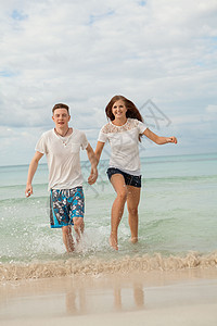 在沙滩上快乐的年轻情侣 暑假爱情 海滩 男朋友图片