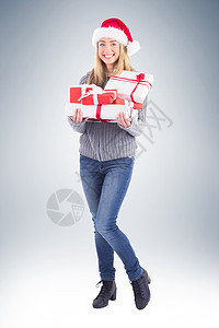 喜庆的金发女郎拿着一堆礼物 浅色头发 牛仔裤 圣诞帽 圣诞节图片