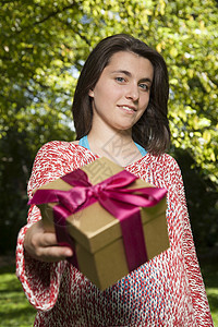 提供礼品盒的年轻妇女图片