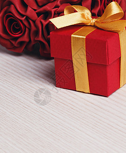 红色鲜花和带有黄丝带的礼品盒 商业 庆典 花朵图片