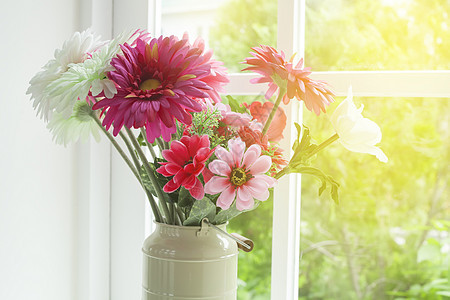 窗边玻璃花瓶中的花朵图片