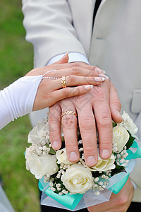手握结婚戒指和花束图片