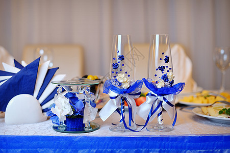 两个杯子和蜡烛放在宴会桌上图片