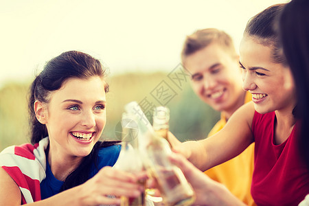 在海滩上饮酒的男女 瓶子 庆典 友谊 柠檬水 户外图片