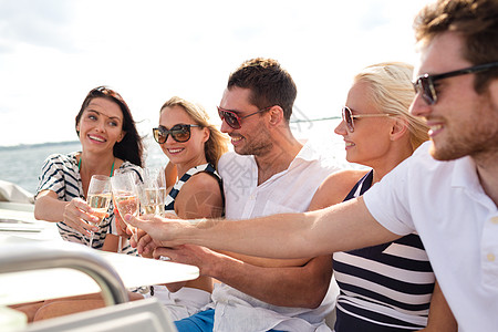 在游艇上带着香槟杯的笑着朋友 旅游 帆图片
