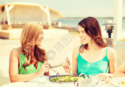 海滩咖啡馆里微笑的姑娘们 吃 阳台 午餐 朋友们图片