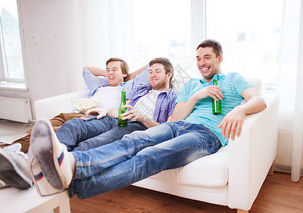 在家喝啤酒看电视的快乐男性朋友 吃 伙计们图片