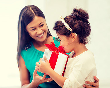 带礼品盒的幸福母亲和少女 微笑 有趣的 圣诞节 孩子们图片