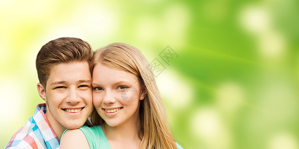 带着微笑的情侣拥抱绿色背景图片