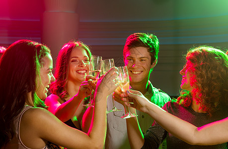 俱乐部里带着香槟杯的笑着朋友 庆祝 假期 晚上图片