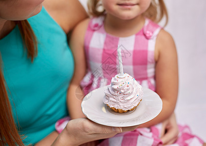 快乐的母亲和小女孩拿着蛋糕纸杯蛋糕图片