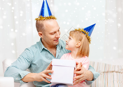 父亲和女儿在带有礼品盒的政党礼帽上 房间 父亲身份图片