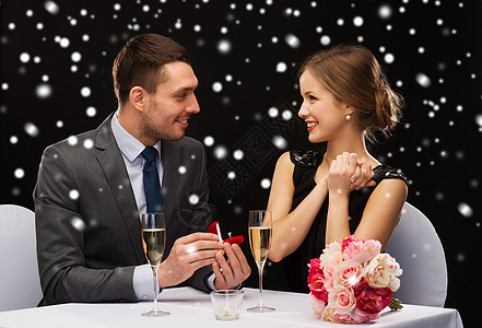 在餐厅微笑的夫妇与红色礼品盒 假期 情人节 香槟酒图片