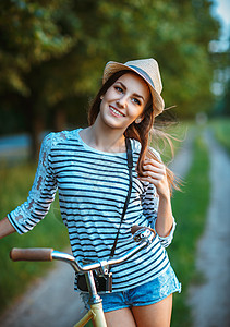 穿着帽子和户外自行车的可爱年轻美女 女性 快乐的图片