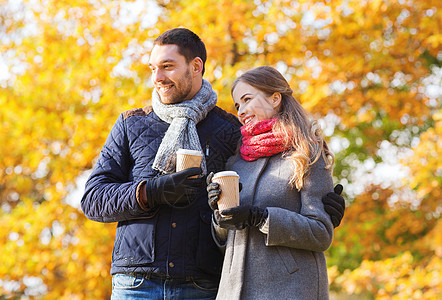 秋天公园里一对带咖啡杯的笑着情侣 家庭 走图片