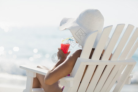 干发帽穿泳衣的棕发美女 太阳帽 坐着 支撑 美丽的 假期背景