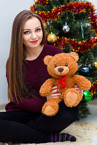 圣诞树附近有泰迪熊的女人图片