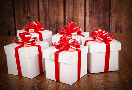 木材背景上许多白色礼物盒 展示 红色的 欢乐 圣诞节图片