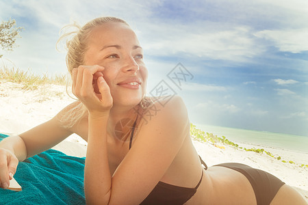 在海滩上穿比基尼的快乐女人 乐趣 躺着 晒黑 海岸线图片