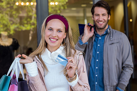 情侣笑脸 用购物袋展示信用卡图片