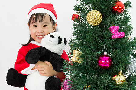 亚裔中国小女孩拿着熊猫娃娃装扮克里斯蒂姆 玩具娃娃 帽图片